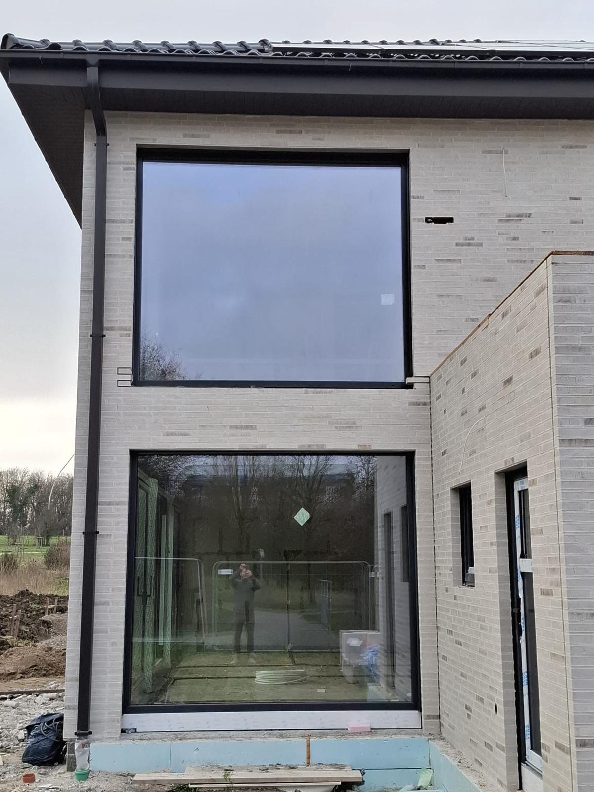 Neubau mit heller Klinkerfassade und zwei großen, übereinanderliegenden Glasflächen